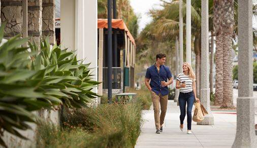 Exterior view of couple walking by Villas at Playa Vista Apartment Homes in Playa Vista, CA.