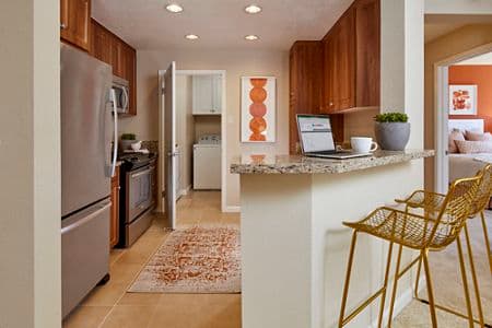 Interior view of kitchen and laundry room at Cherry Orchard Apartment Homes in Sunnyvale, CA.