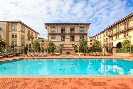 View of building exterior and pool at Verona at Crescent Village Apartment Homes in San Jose, CA.