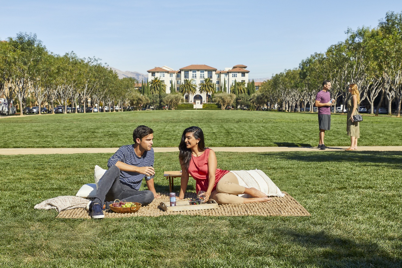 Exterior view of people spending time at outdoor lawn at North Park Apartment Homes in San Jose, CA.