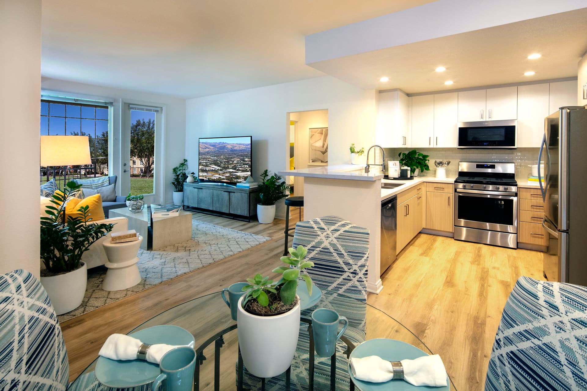 Interior view of a living room and kitchen at The Pines at North Park Apartment Homes in San Jose, CA.