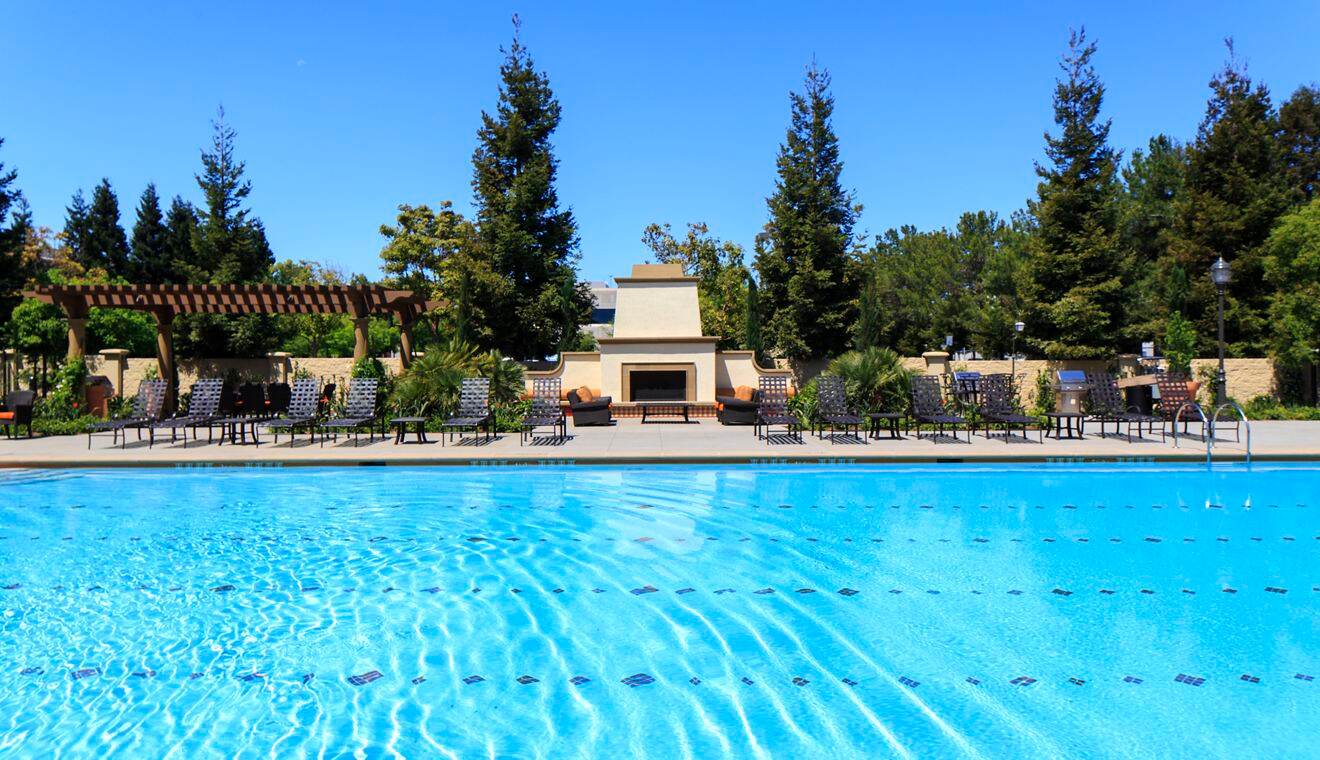 Exterior view of building and pool at Stewart Village Apartment Homes in Sunnyvale, CA.