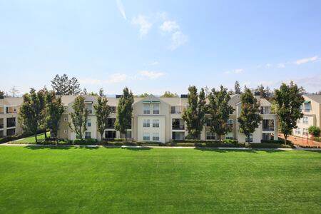 View of building exterior and lawn area at The Hamptons Apartment Homes in Cupertino, CA. 