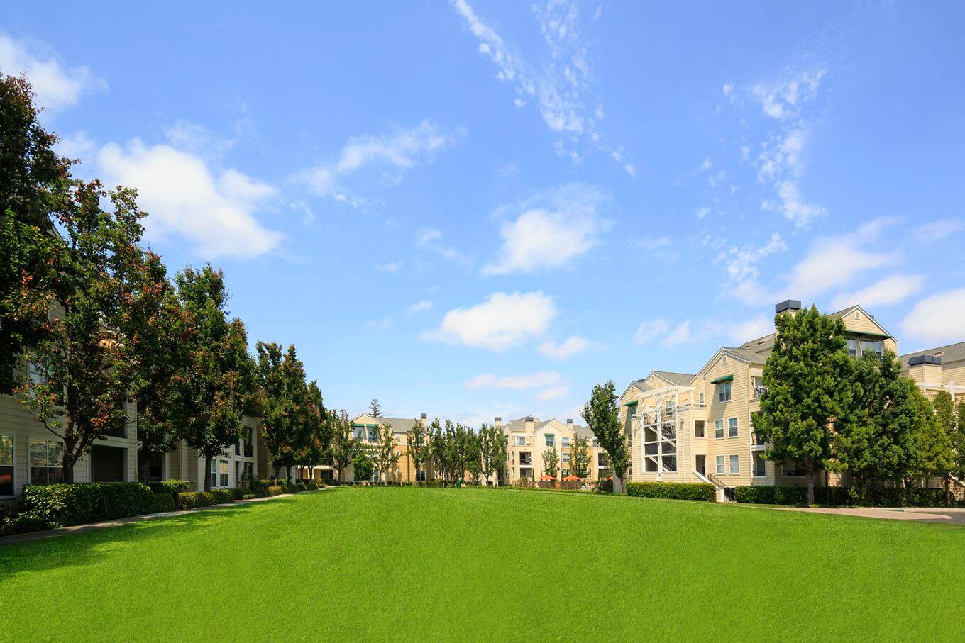 View of building exterior and lawn area at The Hamptons Apartment Homes in Cupertino, CA. 