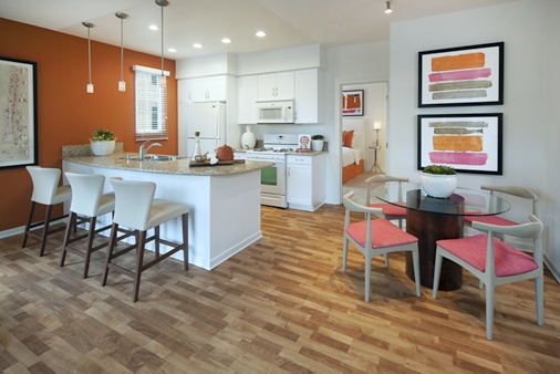 Interior view of dining room and kitchen at The Enclave Apartment Homes in Costa Mesa, CA.
