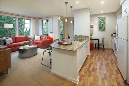 Interior view of living room and kitchen at The Enclave Apartment Homes in Costa Mesa, CA.