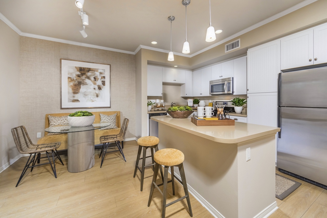 Interior view of kitchen and dining room at Los Olivos Apartment Homes at Irvine Spectrum in Irvine, CA.