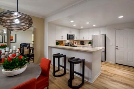 Interior view of kitchen and dining room at Mirador at The Village at Irvine Spectrum Apartment Homes in Irvine, CA.