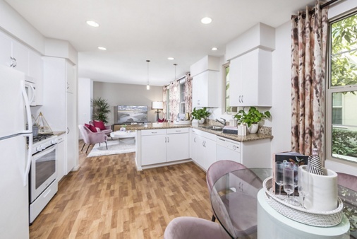 Interior view of the kitchen and living area at Woodbury Court Apartment Homes in Irvine, CA.