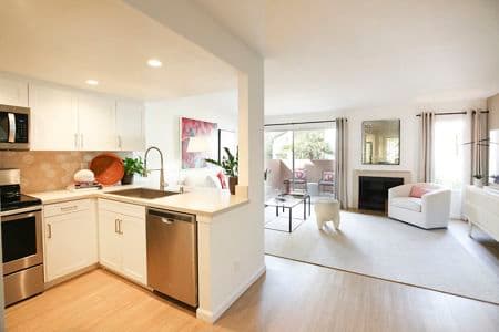 Interior view of kitchen and living room at Newport North Apartment Homes in Newport Beach, CA.