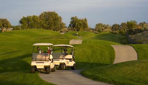 Two golf carts stand on the path beside the ninth hole