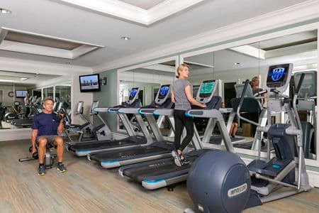 Two people exercising in fitness center at The Colony at Fashion Island Apartment Communities in Newport Beach, CA.