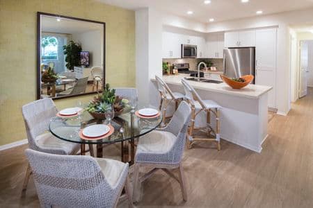 Interior view of a dining space and kitchen at Turtle Ridge Apartment Homes in Newport Beach, CA.