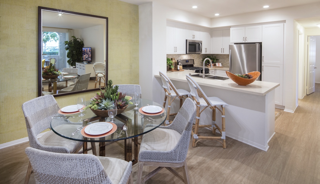 Interior view of a dining space and kitchen at Turtle Ridge Apartment Homes in Newport Beach, CA.