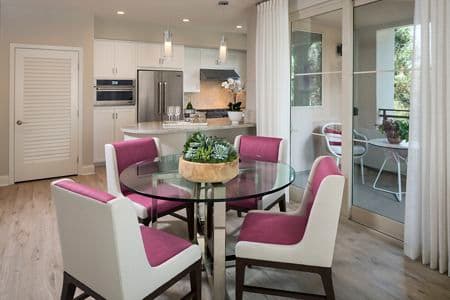 View of dining room, kitchen, and patio at Villas Fashion Island Apartment Homes in Newport Beach, CA.