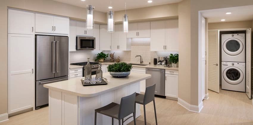 Interior view of kitchen and laundry unit at Villas Fashion Island Apartment Homes in Newport Beach, CA.