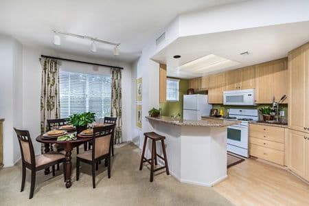 Interior view of dining room and kitchen at Rancho Monterey Apartment Homes in Tustin, CA.