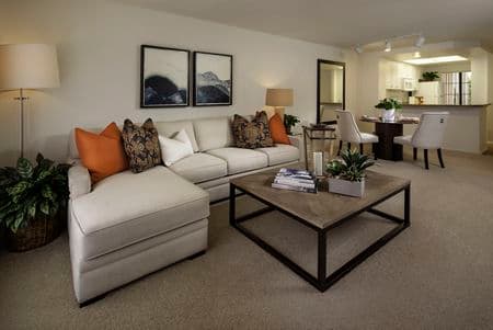 Interior view of living room, dining, and kitchen at Rancho Tierra Apartment Homes in Tustin, CA.