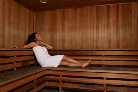 Woman in sauna amenity at Solazzo Apartment Homes in La Jolla, CA.