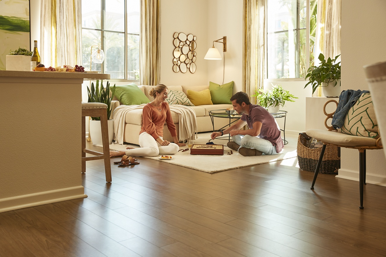 Interior view of couple playing board game in living room at Irvine Company Apartment Communities.