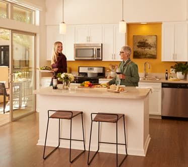 Interior view of women in kitchen at Irvine Company Apartment Communities.