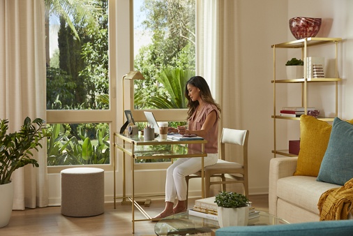 Interior view of woman working from home at Promenade Apartment Homes in Irvine, CA.