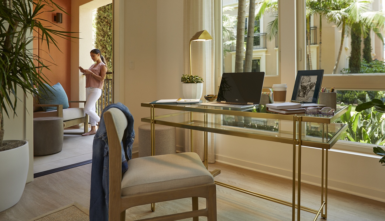 Interior view of woman working from home at Promenade Apartment Homes in Irvine, CA.