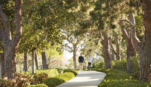 Exterior view of people walking on ped pathway at Paseo Westpark in Irvine, CA.