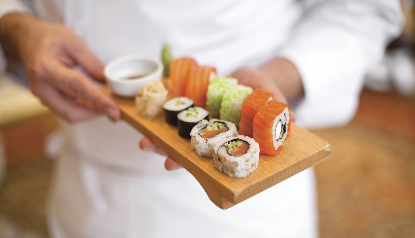sushi chef holding sushi plate.(shallow depth of field)