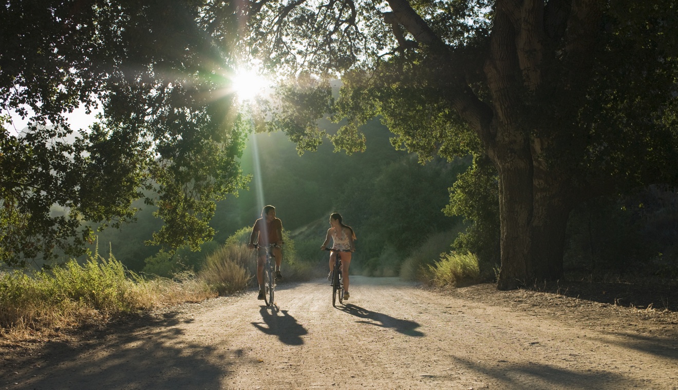 young couple biking down dirt road