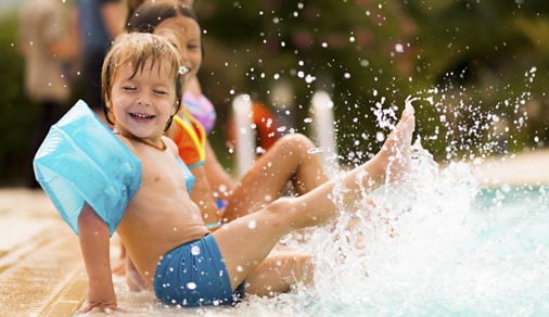 Kids in swimming pool have fun and splashing water