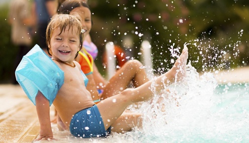 Kids in swimming pool have fun and splashing water