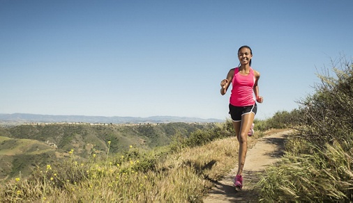 Mixed race girl running on hillside path