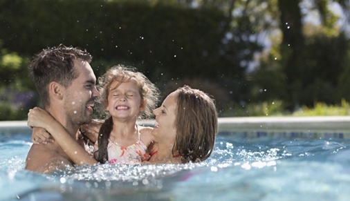 Photo of a family playing in a swimming pool.