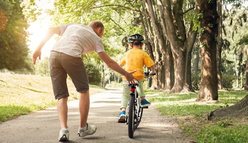 Father learn his little son to ride a bicycle