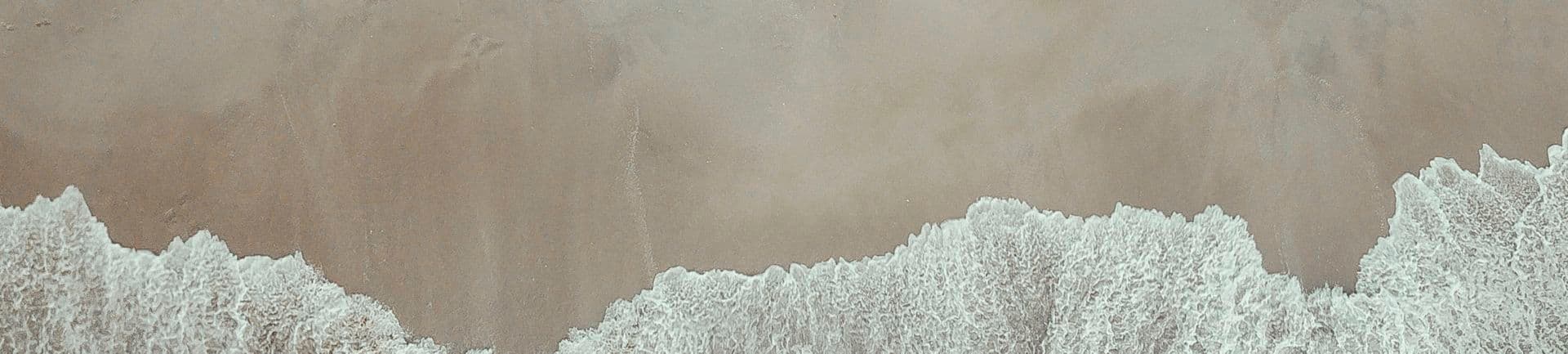 Aerial photo of surfers at the beach.