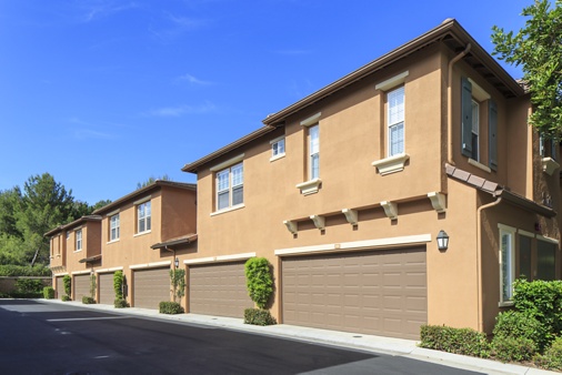 View of building exterior and garage at Bordeaux Apartment Homes in Newport Beach, CA. 