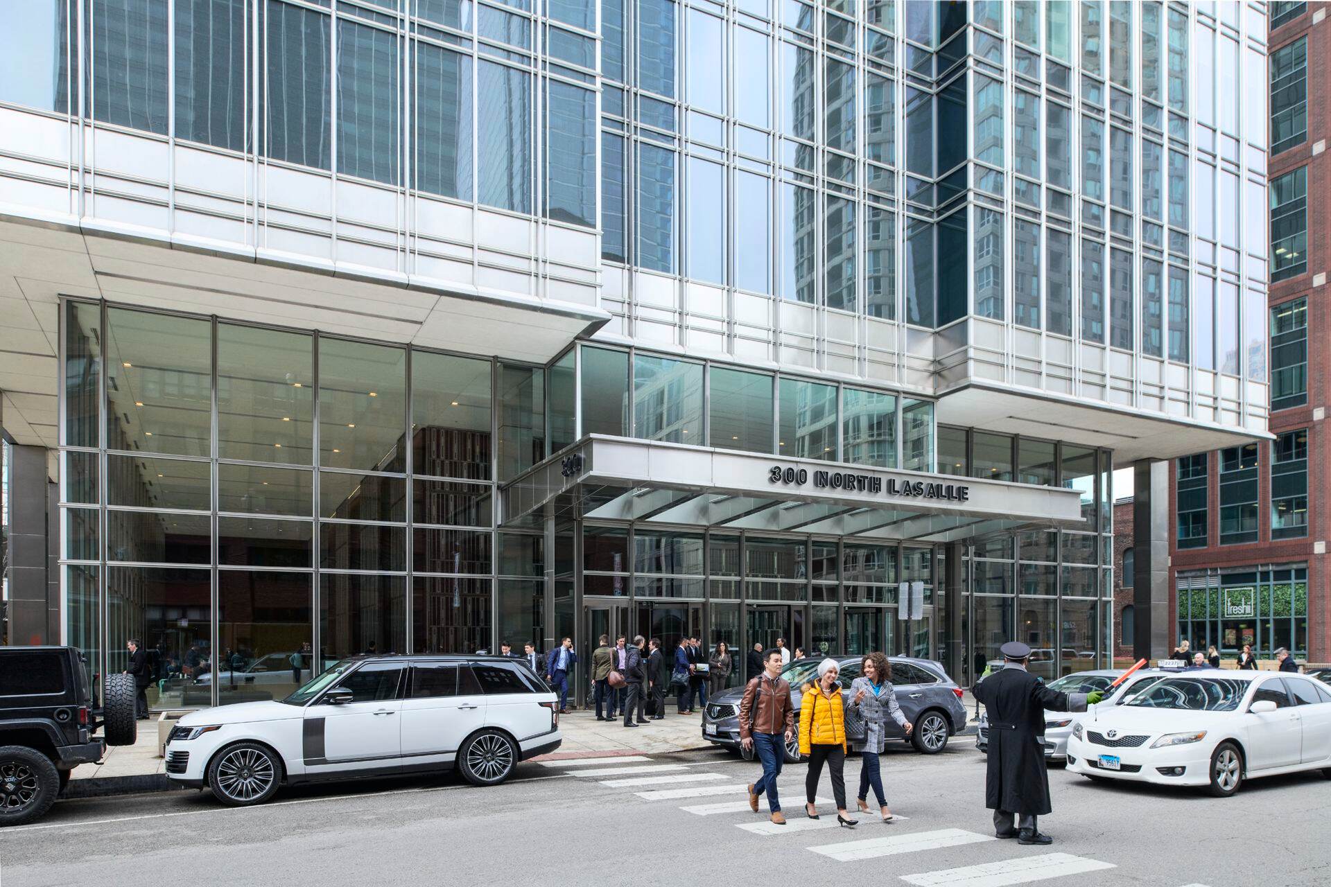Lfiestyle photography of the building exterior and crosswalk at 300 North LaSalle in Chicago, IL