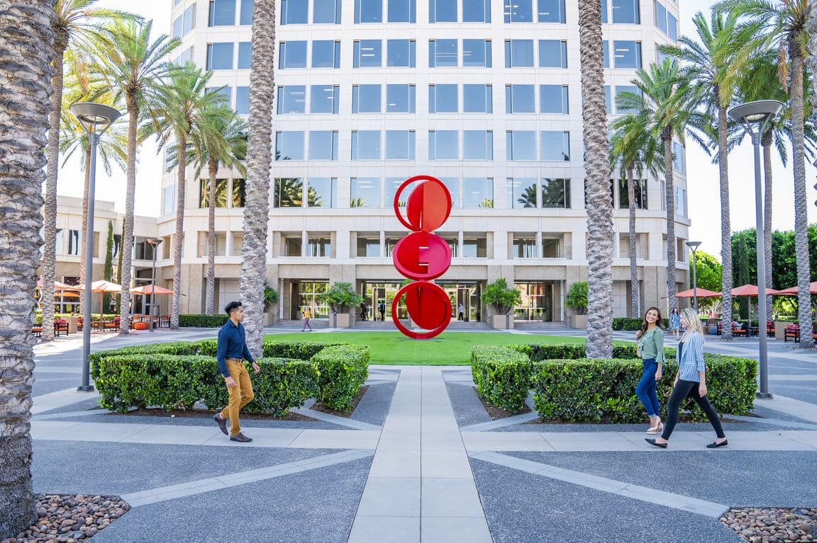 Exterior view of people at The Commons outdoor workspace at the 100 Spectrum Center Drive office building in Irvine, CA.