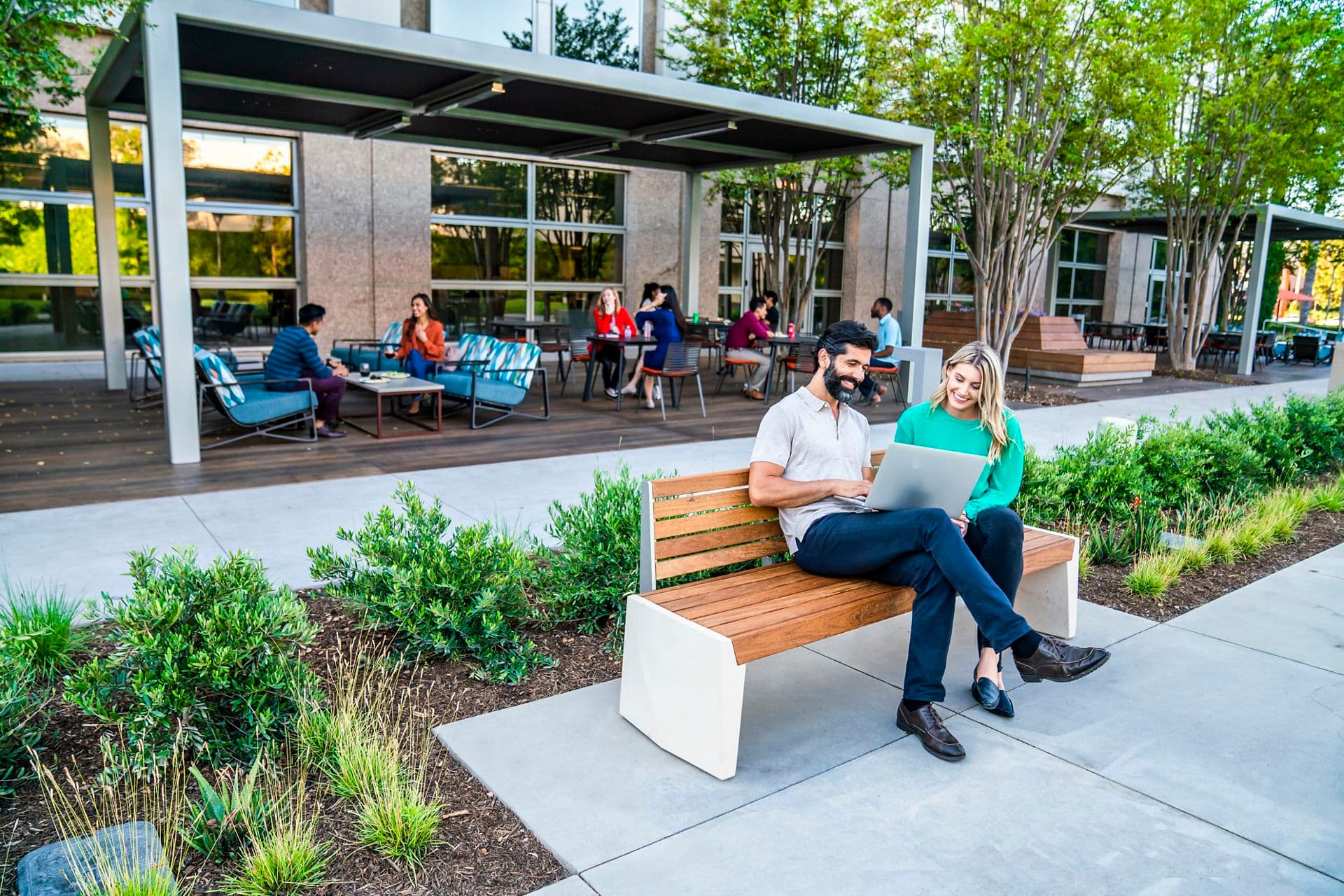 Exterior view of people at The Commons outdoor workspace at the 100 Spectrum Center Drive office building in Irvine, CA.